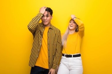 Canlı sarı arka plan üzerinde Genç çift sadece bir şey fark etti ve çözüm niyetinde