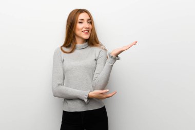 Kızıl saçlı kız elleri yanına gelmek için davet için uzanan beyaz duvar üzerinde