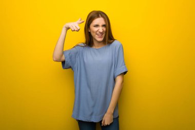 Sarı duvar arka plan kötü bir durum ve önüne'na giderek hayal kırıklığına uğramış genç Kızıl saçlı kız