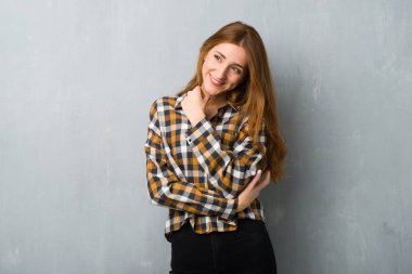 Genç Kızıl saçlı kız tarafına el ile çeneme seyir grunge duvarın üzerinden