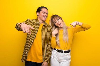 Canlı sarı arka plan üzerinde Genç çift kötü bir durum tarafından sinirli ve ön işaret