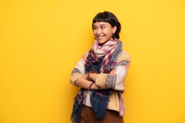 Genç hippi kadını gülümseyen süre ararken sarı duvarın üzerinden