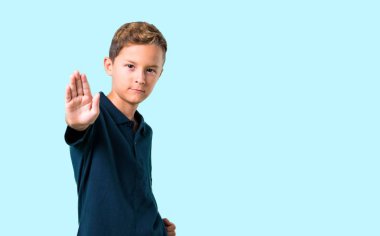 Küçük çocuk yapma dur jest elinde mavi arka plan ile