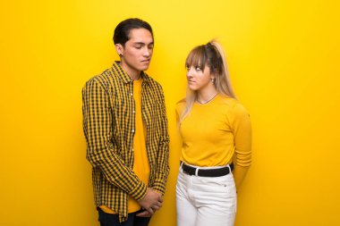 Canlı sarı arka plan üzerinde genç çift üzgün duygu