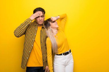 Yorgun ve hasta ifade ile canlı sarı arka plan üzerinde Genç çift