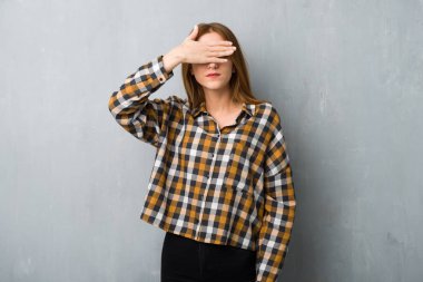 Grunge duvar eller tarafından gözleri kaplama genç Kızıl saçlı kız. Bir şey görmek istiyor musunuz