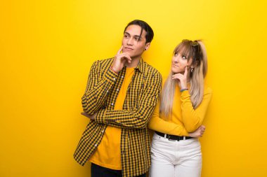 Canlı sarı arka plan üzerinde genç çift ararken bir fikir düşünme