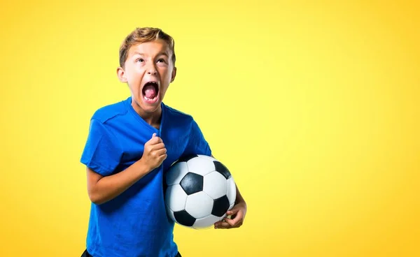 Gelukkige Jongen Voetballen Gele Achtergrond — Stockfoto