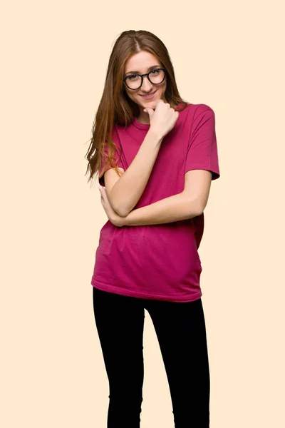 メガネと分離された黄色の背景に笑顔の若い赤毛の女の子 — ストック写真