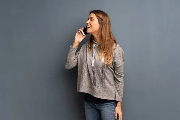 Mujer Rubia Sobre Fondo Gris Manteniendo Una Conversación Con Teléfono — Foto de Stock