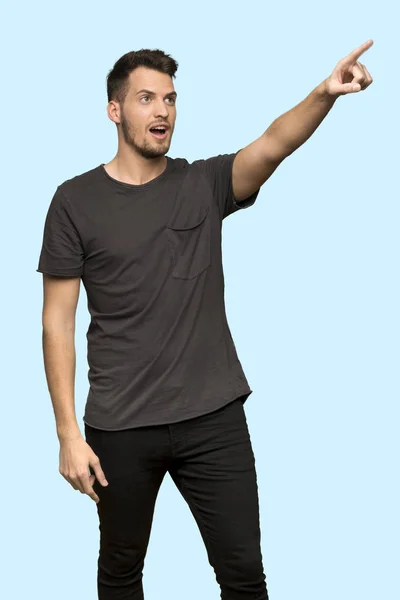 Mężczyzna Czarną Koszulę Wskazującego Niebieskim Tle — Zdjęcie stockowe