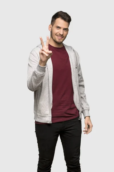 Man Sweatshirt Smiling Showing Victory Sign Grey Background — Stock Photo, Image