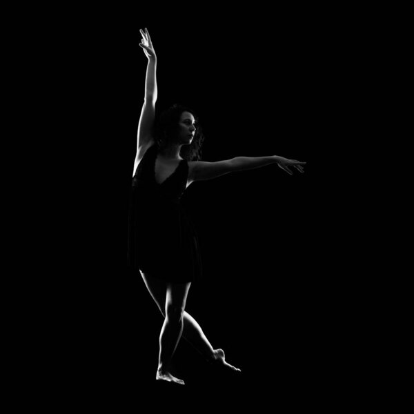 Girl ballet dancer on black background