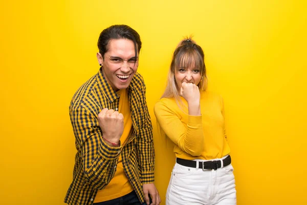 Junges Paar Vor Leuchtend Gelbem Hintergrund Feiert Einen Sieg — Stockfoto