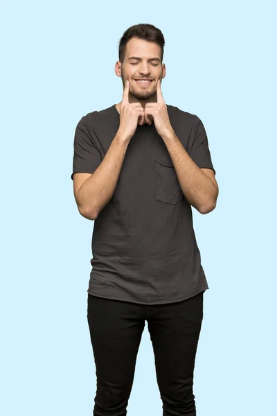 Мужчина Черной Рубашке Улыбается Счастливым Приятным Выражением Лица Синем Фоне — стоковое фото