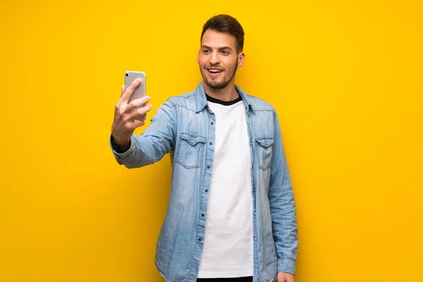 Schöner Mann Über Gelber Wand Macht Ein Selfie — Stockfoto