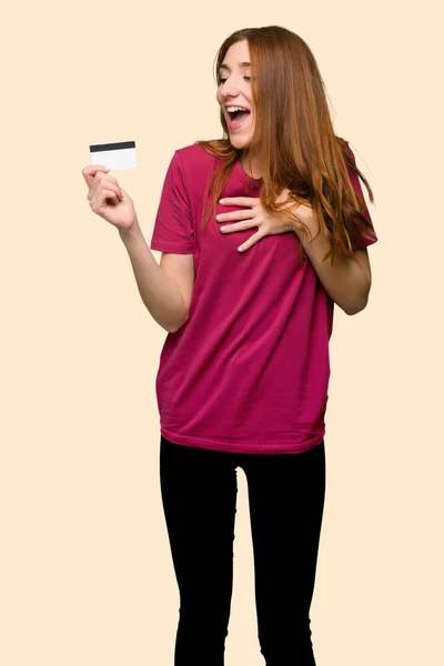 Νέοι Κοκκινομάλλα Κοπέλα Κρατώντας Μια Πιστωτική Κάρτα Και Έκπληκτος Απομονωμένες — Φωτογραφία Αρχείου