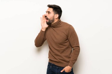 Beyaz duvar için lateral açık ağızlı bağırmayı yakışıklı adam