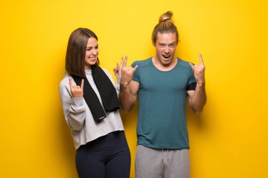 Grup rock jest yaparak sarı arka plan üzerinde sporcuların