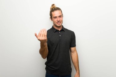 Beyaz duvar el ile gelmek davet üzerine uzun saçlı sarışın adam. Mutlu sen geldin