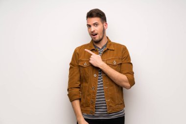 Yakışıklı adam şaşırttı ve yan işaret beyaz duvar