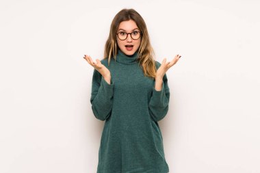 Genç kız sürpriz ve şok yüz ifadesi ile beyaz duvar üzerinde