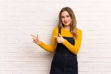 Genç kız beyaz tuğla duvar işaret parmağı yanında üzerinde