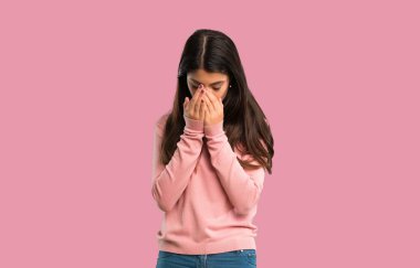 Yorgun ve hasta ifade izole pembe bir arka plan üzerinde pembe gömlek ile genç kız