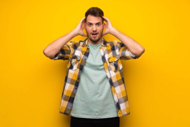 Yakışıklı adam şaşırttı ve doğru bakarken şok sarı duvarın üzerinden