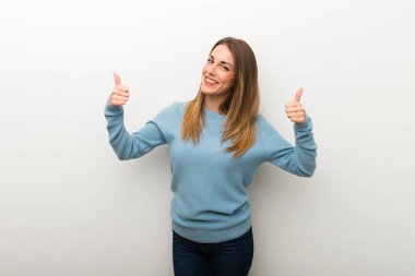 Her iki el ile jest Yaşasın vererek ve gülümseyen izole beyaz arka plan üzerinde sarışın kadın