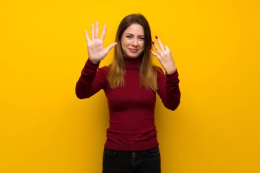 Balıkçı yaka sekiz parmak ile sayma sarı duvarın üzerinden kadınla