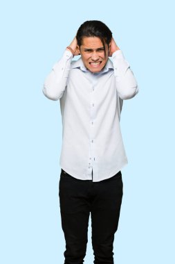 Yakışıklı adam izole mavi arka plan üzerinde migren çünkü kafasına el alır