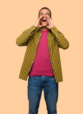 Bağırarak ve izole arka planda bir şey ilan genç afro Amerikalı adam