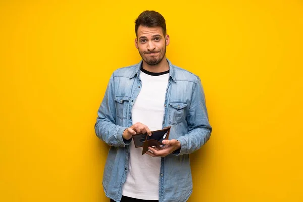 Handsome Man Yellow Wall Holding Wallet — Stock Photo, Image