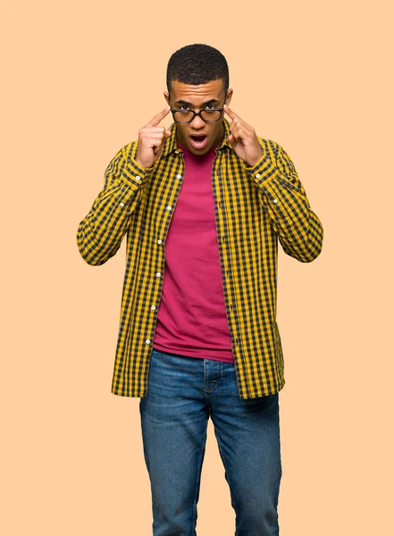アメリカの若いのアフロ男眼鏡と孤立した背景に驚いた — ストック写真