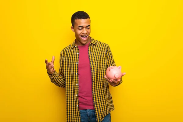 Jonge Afro Amerikaanse Man Gele Achtergrond Verrast Terwijl Een Spaarpot — Stockfoto