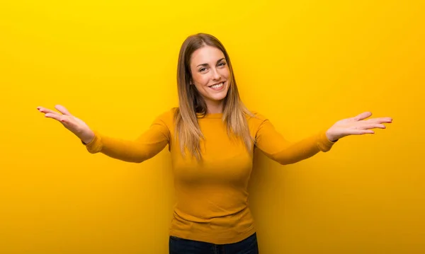 Mujer Joven Sobre Fondo Amarillo Presentando Invitando Venir Con Mano —  Fotos de Stock