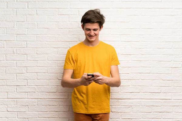 Teenager Mann Über Weiße Backsteinmauer Sendet Eine Nachricht Mit Dem — Stockfoto