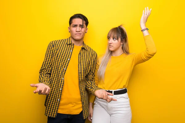 Junges Paar Über Lebendigen Gelben Hintergrund Unglücklich Und Frustriert Über — Stockfoto