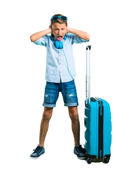 全身都是戴着太阳镜和耳机的孩子 带着他的手提箱在孤立的白色背景上用双手捂着两只耳朵 — 图库照片