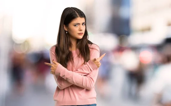 Tiener Meisje Met Roze Shirt Wijzend Naar Laterals Twijfels Bij — Stockfoto