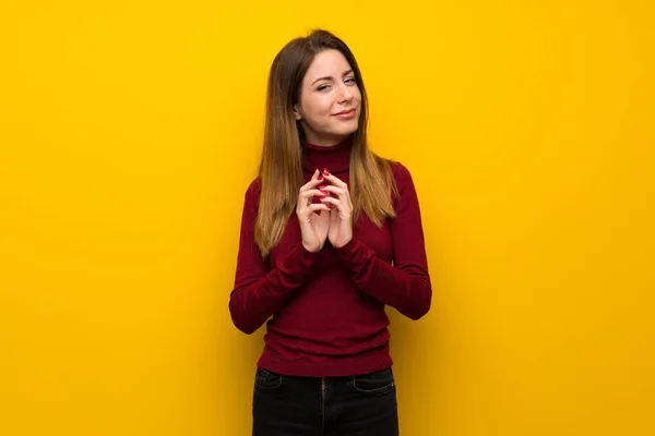 Vrouw Met Coltrui Gele Muur Gekonkel Iets — Stockfoto