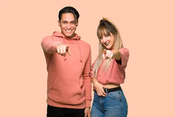 Молода Пара Вказує Пальцем Впевненим Виразом Над Рожевим Тлом — стокове фото