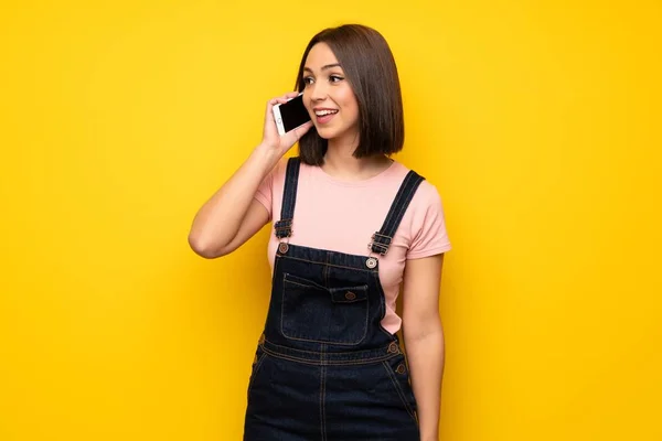 Mujer Joven Sobre Pared Amarilla Manteniendo Una Conversación Con Teléfono — Foto de Stock