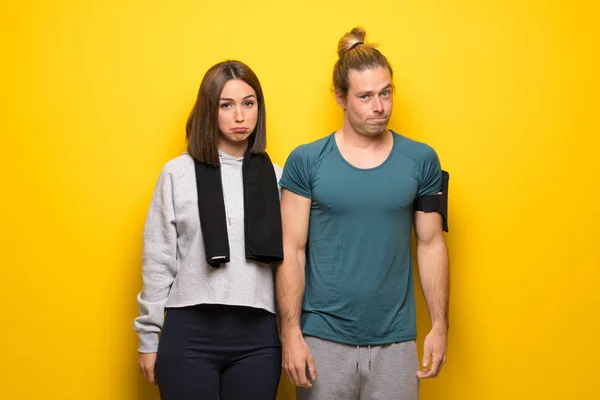 Group of athletes over yellow background with sad and depressed expression
