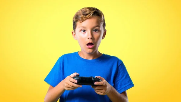 Kid Tocando Console Fundo Amarelo — Fotografia de Stock