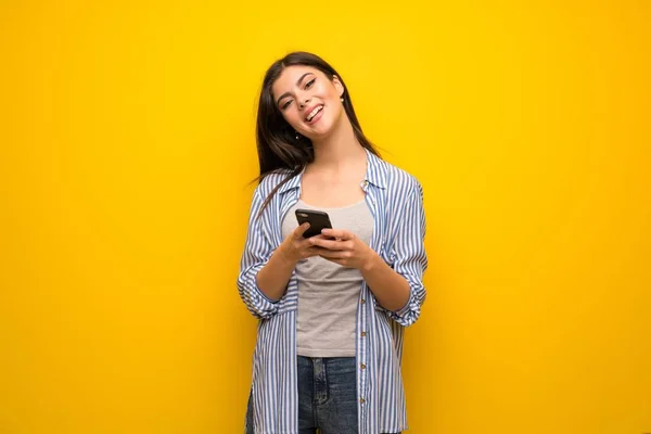 Adolescente Chica Sobre Amarillo Pared Enviando Mensaje Con Móvil — Foto de Stock