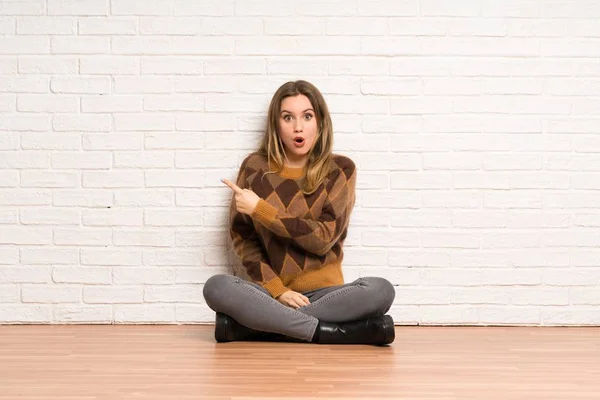 Teenager Mädchen Sitzt Auf Dem Boden Überrascht Und Zeigt Seite — Stockfoto