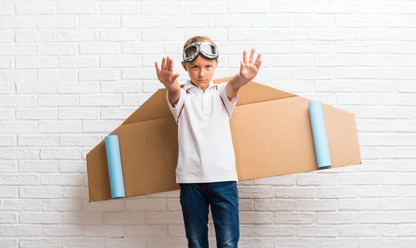 Boy Playing Cardboard Airplane Wings His Back Making Stop Gesture — Stock Photo, Image
