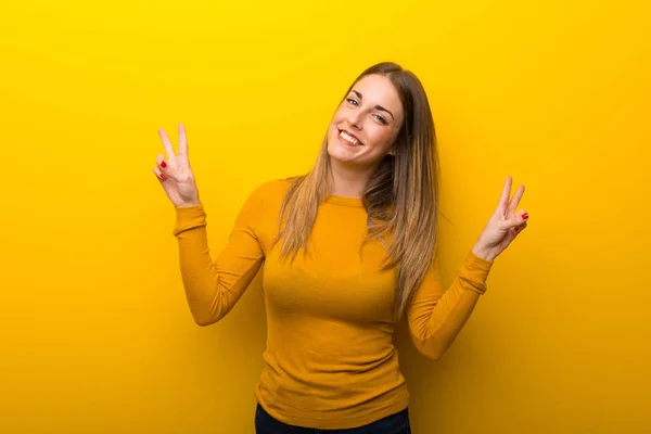 Mujer Joven Sobre Fondo Amarillo Sonriendo Mostrando Signo Victoria Con —  Fotos de Stock